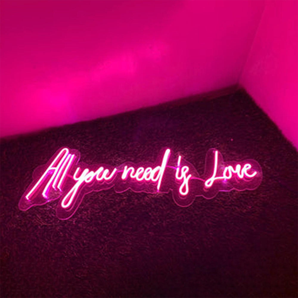 Pink neon light with the text "all you need is love"
